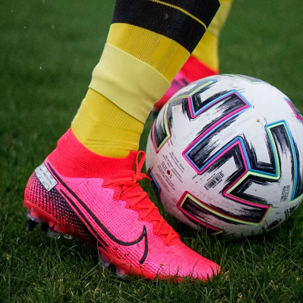 Bande silicone en action sur le terrain, maintien sécurisé des protège-tibias pendant le match de football
